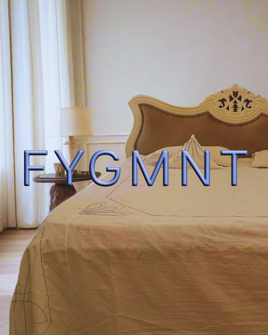 Close-up of hand-embroidered hemp bedsheets, pillow covers and cushions on a king size bed.